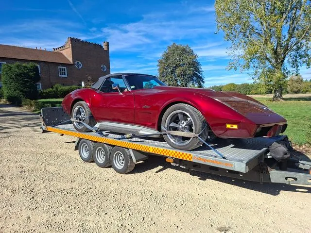 Red Corvette convertible strapped on the car trailer