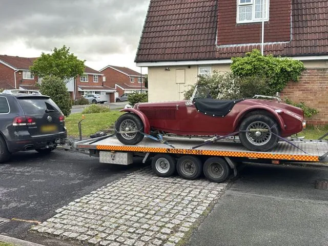 Vintage red roadster on the trailer behind the Touareg